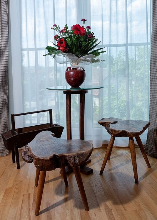 image of a room with two stools, a coffee table and magazine rack carved out of wood