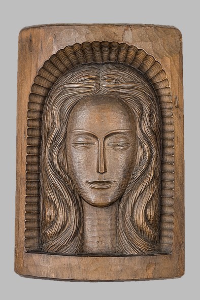 image of a carving in wood representing a young female