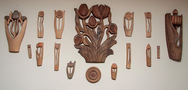 Picture of a wall display of flowers carved in wood; private collection